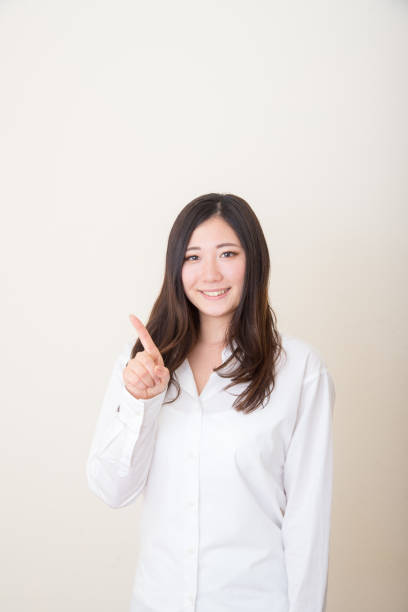 istock asian woman pointing with index finger 1041968016