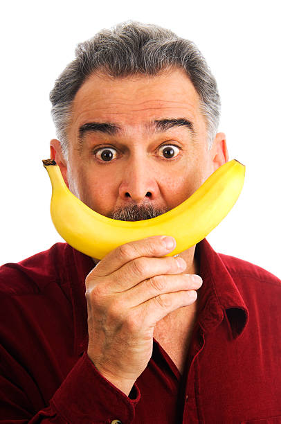 istock Man hold banana to face, imitating smile 104197241