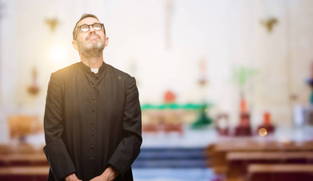 istock Priest religion man thinking and looking up expressing doubt and wonder 1041972444