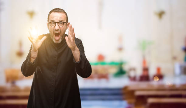 istock Priest religion man stressful keeping hands on head, terrified in panic, shouting 1041972482
