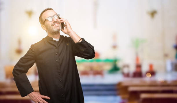 istock Priest religion man happy talking using a smartphone mobile phone 1041972612