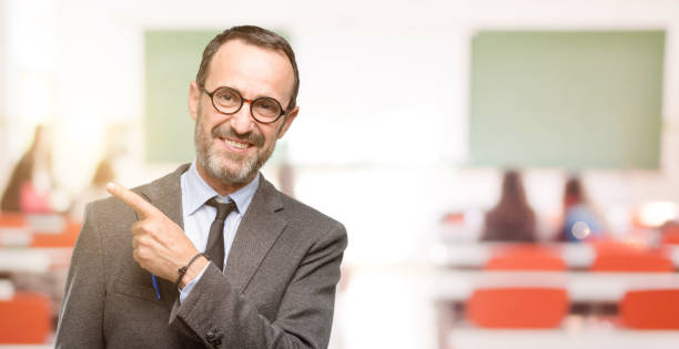 istock Teacher man using glasses pointing away side with finger 1041972648