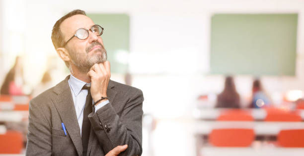 istock Teacher man using glasses thinking and looking up expressing doubt and wonder 1041972718