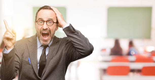 istock Teacher man using glasses pointing away side with finger 1041972818