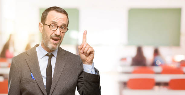istock Teacher man using glasses pointing away side with finger 1041972944