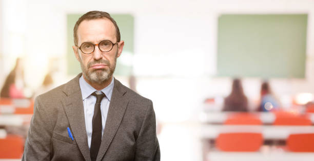 istock Teacher man using glasses with sleepy expression, being overworked and tired 1041972972