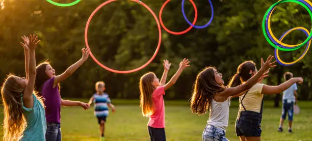 Children playing with plastic hoops in park