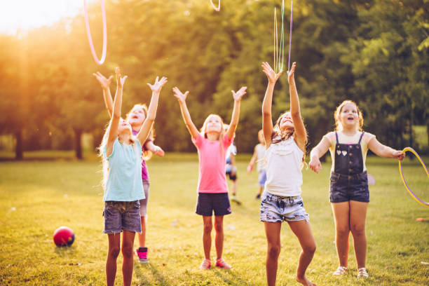 istock Girls throwing up plastic hoop in public park 1041976304