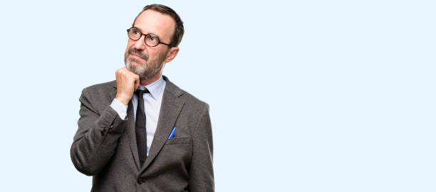 istock Teacher man using glasses thinking and looking up expressing doubt and wonder 1041976894