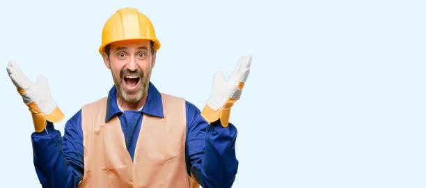 istock Senior engineer man, construction worker happy and surprised cheering expressing wow gesture 1041977706
