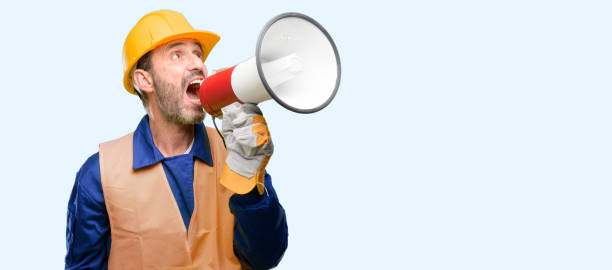 istock Senior engineer man, construction worker communicates shouting loud holding a megaphone, expressing success and positive concept, idea for marketing or sales 1041977908