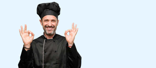 istock Senior cook man, wearing chef hat doing ok sign gesture with both hands expressing meditation and relaxation 1041978378