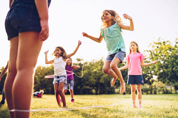 istock Children playing in park with rubber band and hoops 1041980734