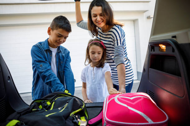 istock Mother and children loading school backpacks into car 1041982800