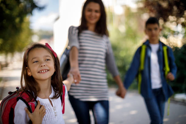 Mother and kids going home from school