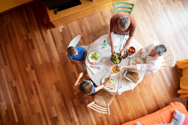 LGBTQ Family eating together Gay Couple with two children eating together gay dinner table stock pictures, royalty-free photos & images