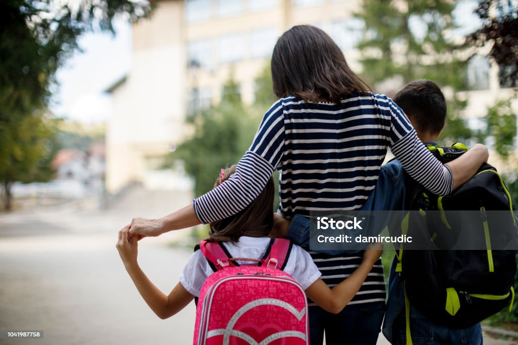 Madre porta i bambini a scuola - Foto stock royalty-free di Edificio scolastico