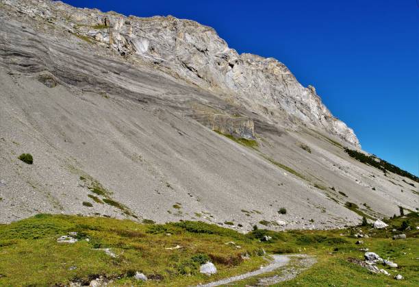 las etapas iniciales de la gemmi pass en sunnbuel, arriba kandersteg en las fronteras de los alpes de wallis en la suiza central y bernese en cristal claro sol de otoño temprano - gemmi fotografías e imágenes de stock