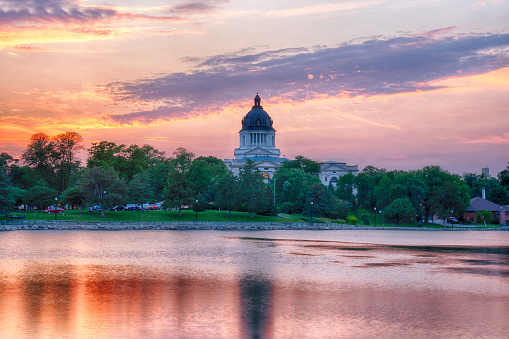 PIERRE, SD - JULY 9, 2018: South Dakota Capital Building along Capitol Lake in Pierre, SD at sunset