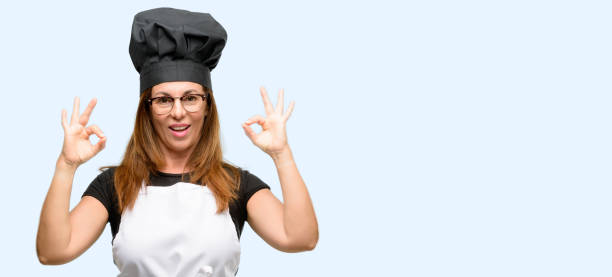 istock Middle age cook woman wearing chef apron doing ok sign gesture with both hands expressing meditation and relaxation 1042007712