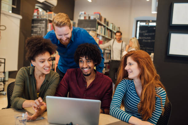 istock Happy young people with laptop 1042007720