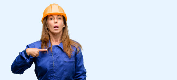 istock Engineer construction worker woman happy and surprised cheering expressing wow gesture, pointing with finger 1042010848