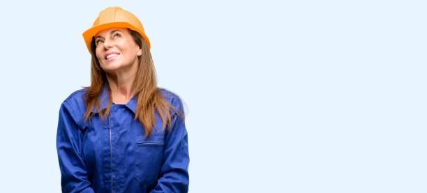 Engineer construction worker woman thinking and looking up expressing doubt and wonder