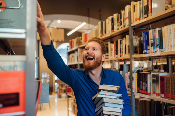istock Happy man looking at the book shelf 1042011272