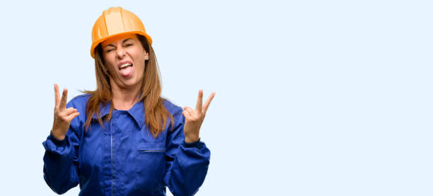istock Engineer construction worker woman looking at camera showing tong and making victory sign with fingers 1042011370