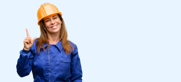 istock Engineer construction worker woman pointing away side with finger 1042011426