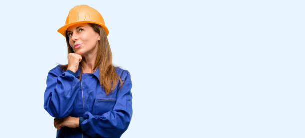istock Engineer construction worker woman thinking and looking up expressing doubt and wonder 1042011502