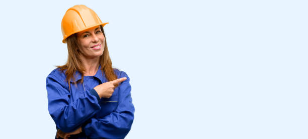 istock Engineer construction worker woman pointing away side with finger 1042011588