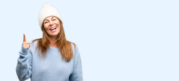 istock Middle age woman wearing wool winter cap pointing away side with finger 1042012238