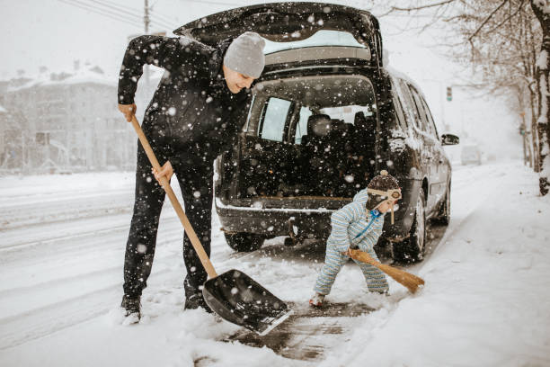 vater und söhnlein schnee rund um auto reinigung - snow cleaning stock-fotos und bilder