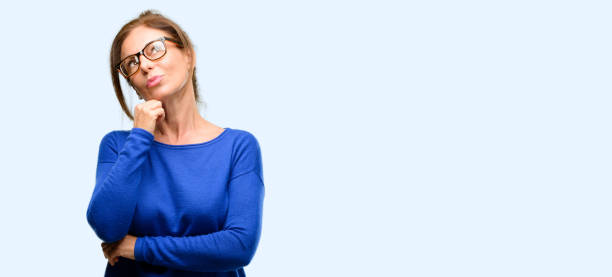 istock Middle age woman wearing wool sweater and glasses thinking and looking up expressing doubt and wonder 1042013506