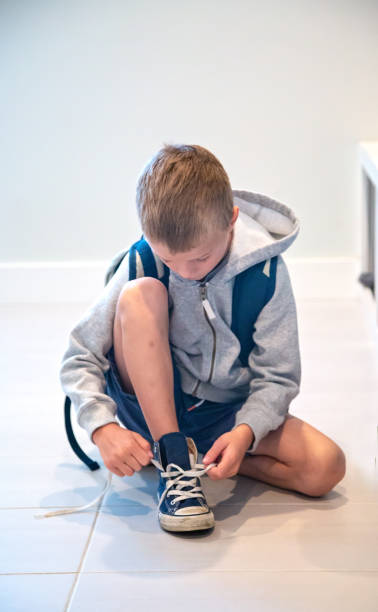 istock Young Boy Ties His Shoe Laces 1042016346