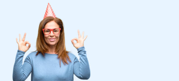 istock Middle age woman celebrates birthday doing ok sign gesture with both hands expressing meditation and relaxation 1042016374