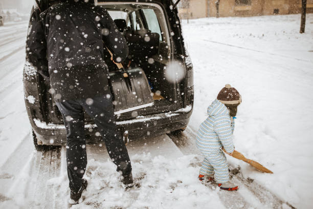 istock Father and little son cleaning snow around car 1042016434