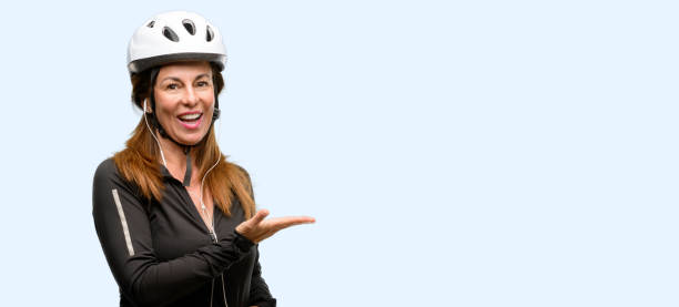 istock Middle age cyclist woman using earphones holding something in empty hand 1042020572
