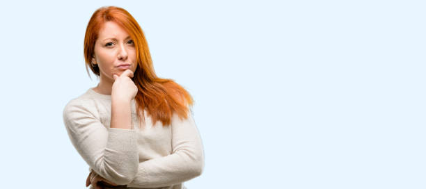 istock Beautiful young redhead woman thinking thoughtful with smart face 1042020810