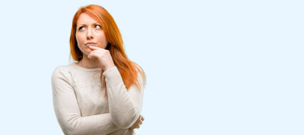 istock Beautiful young redhead woman doubt expression, confuse and wonder concept, uncertain future 1042020858