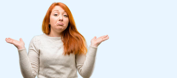 Beautiful young redhead woman doubt expression, confuse and wonder concept, uncertain future