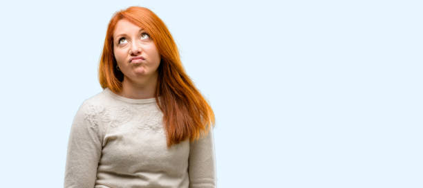 istock Beautiful young redhead woman making funny face fooling 1042021068