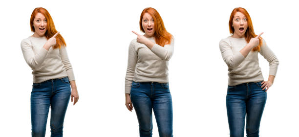 istock Young Beautiful redhead woman pointing away side with finger 1042021574