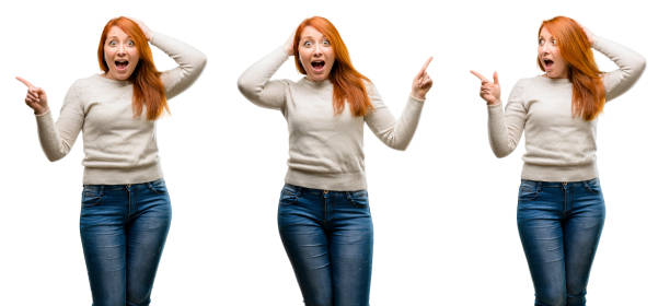 istock Young Beautiful redhead woman pointing away side with finger 1042022134