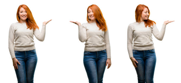 istock Young Beautiful redhead woman holding something in empty hand 1042024910