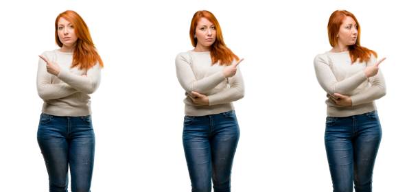 istock Young Beautiful redhead woman pointing away side with finger 1042024984