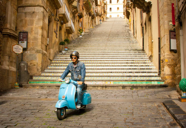 caltagirone, sicily: hip young man on blue vespa scooter - vespa scooter imagens e fotografias de stock