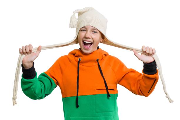 primo piano del ritratto invernale di una ragazza attraente in berretto a maglia 12,13 anni che si diverte, isolata su sfondo bianco - teenager 14 15 years 13 14 years cheerful foto e immagini stock
