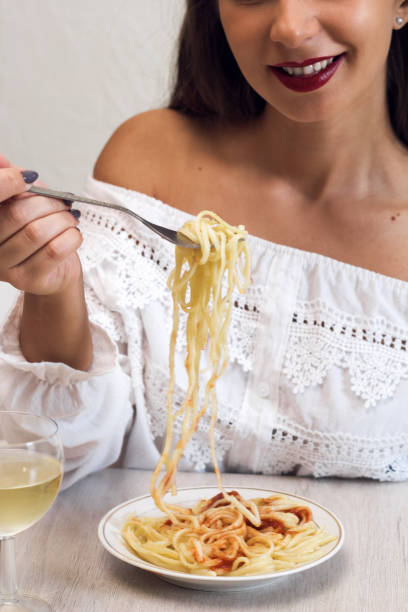 istock beautiful young woman eating pasta 1042033450